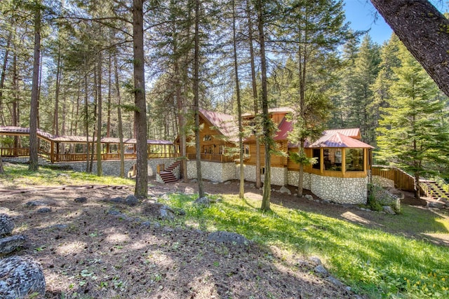 1062 Bear Creek Trl, Victor, MT 59875 - view of yard featuring stairs, a wooden deck, and a forest view