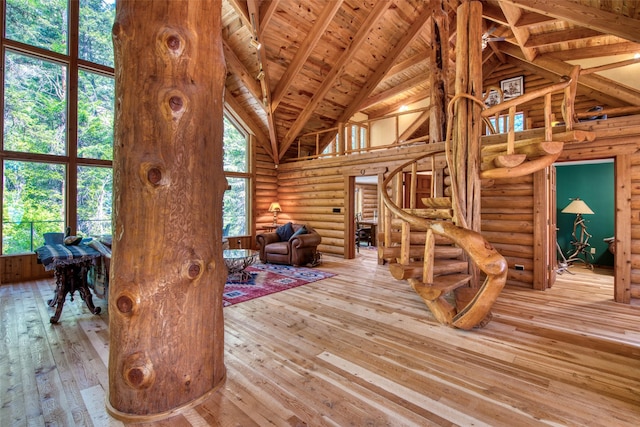1062 Bear Creek Trl, Victor, MT 59875 - unfurnished living room with high vaulted ceiling, rustic walls, wood-type flooring, a wood ceiling with exposed beams, and stairway