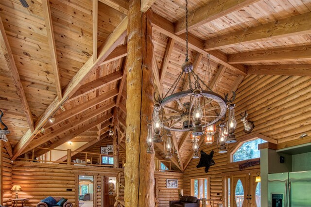 1062 Bear Creek Trl, Victor, MT 59875 - detailed view of stainless steel refrigerator with ice dispenser, rustic walls, a wood ceiling with exposed beams, and a chandelier