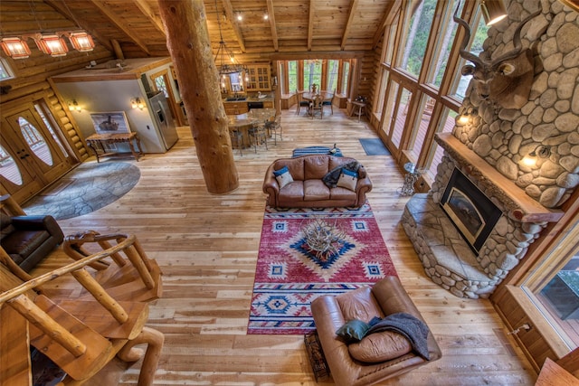 1062 Bear Creek Trl, Victor, MT 59875 - living area featuring a wood ceiling with exposed beams, light wood-style flooring, a fireplace, and rustic walls