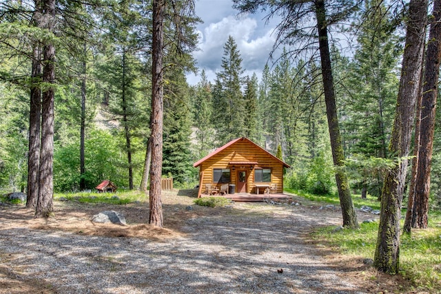 1062 Bear Creek Trl, Victor, MT 59875 - view of front facade featuring a wooded view and faux log siding
