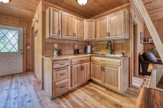 1062 Bear Creek Trl, Victor, MT 59875 - kitchen with wooden ceiling, light brown cabinetry, wooden walls, light wood-type flooring, and light countertops
