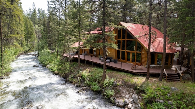 1062 Bear Creek Trl, Victor, MT 59875 - rear view of house with a wooded view, a wooden deck, and a metal roof