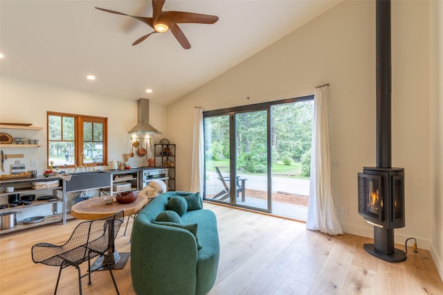 135 Gamma Rd, Hungry Horse, MT 59919 - living room with a ceiling fan, light wood finished floors, recessed lighting, high vaulted ceiling, and a wood stove