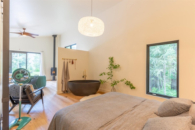 135 Gamma Rd, Hungry Horse, MT 59919 - bedroom featuring a wood stove, light wood-style floors, and a towering ceiling