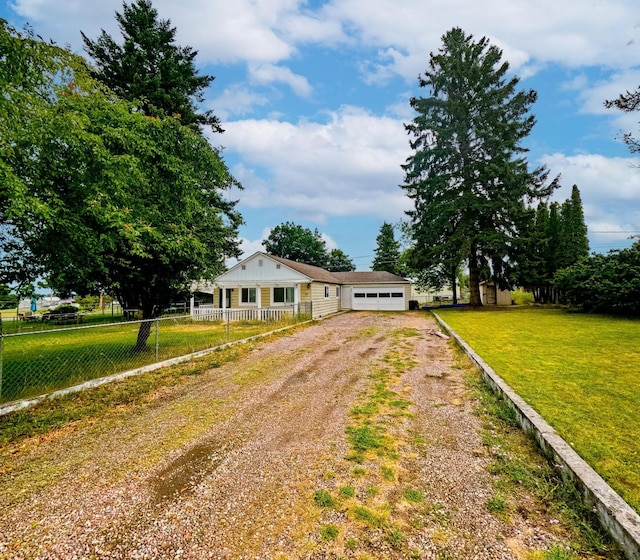 1203 1st St E, Polson, MT 59860 - view of front of home with dirt driveway and a garage