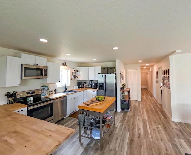 1203 1st St E, Polson, MT 59860 - kitchen featuring appliances with stainless steel finishes, butcher block countertops, a sink, open shelves, and recessed lighting