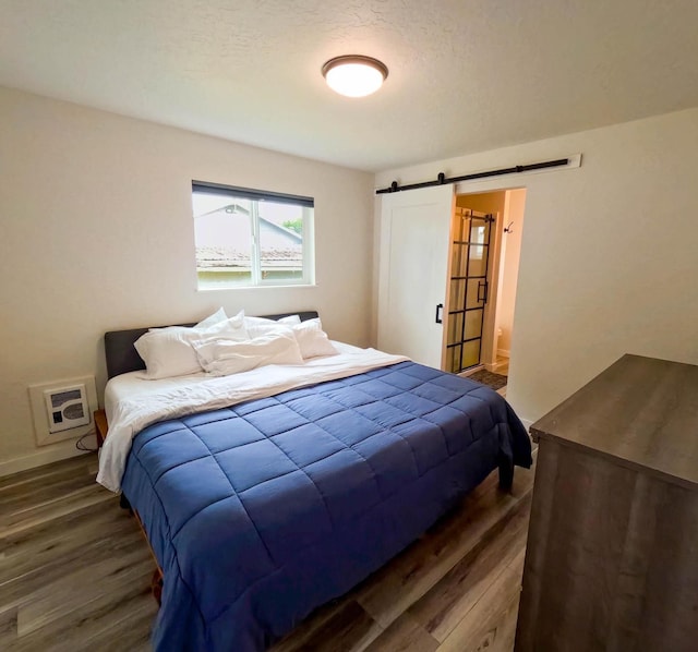 1203 1st St E, Polson, MT 59860 - bedroom with a barn door, wood finished floors, and baseboards