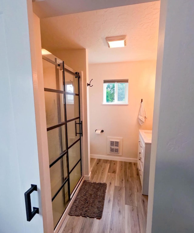 1203 1st St E, Polson, MT 59860 - bathroom with vanity, a stall shower, wood finished floors, and baseboards