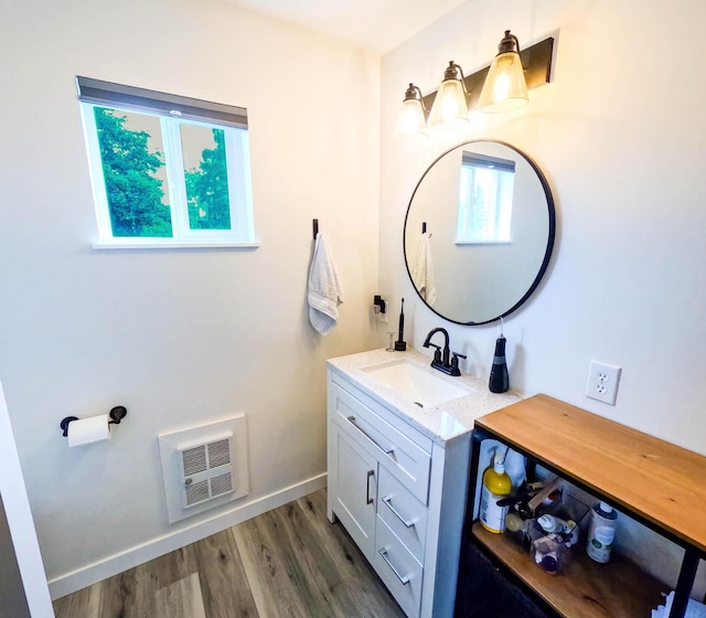 1203 1st St E, Polson, MT 59860 - bathroom with vanity, heating unit, wood finished floors, and baseboards