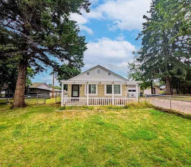 1203 1st St E, Polson, MT 59860 - view of front facade with covered porch, driveway, board and batten siding, and a garage