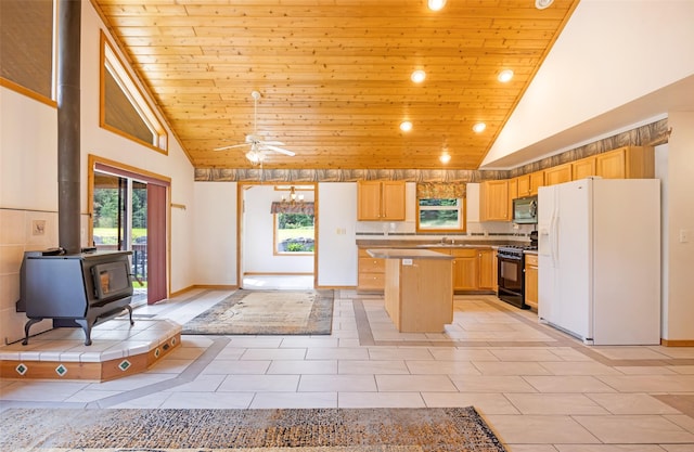 1065 Evergreen Dr, Seeley Lake, MT 59868 - kitchen featuring black range with gas cooktop, white fridge with ice dispenser, wooden ceiling, a wood stove, and plenty of natural light