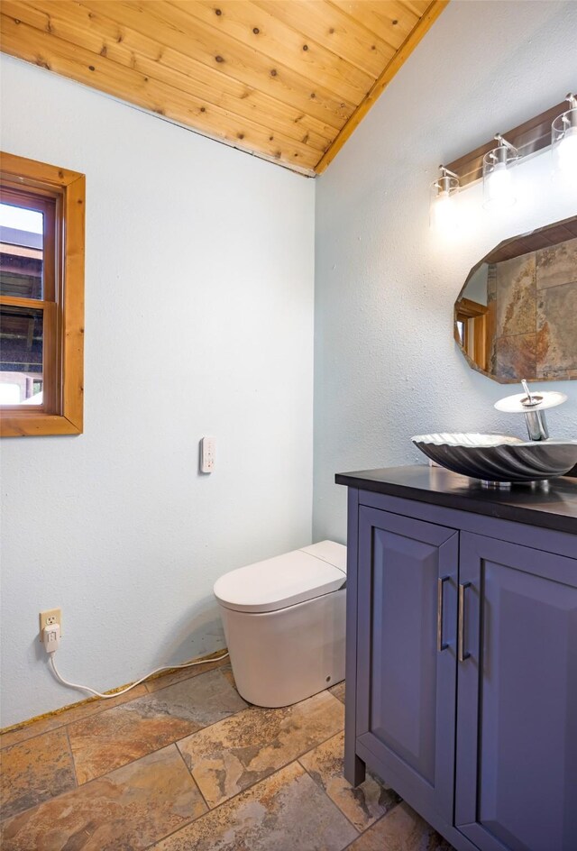 1065 Evergreen Dr, Seeley Lake, MT 59868 - bathroom with stone tile floors, vanity, vaulted ceiling, and wood ceiling