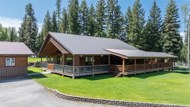 1065 Evergreen Dr, Seeley Lake, MT 59868 - view of front of home with a front yard, covered porch, and a metal roof
