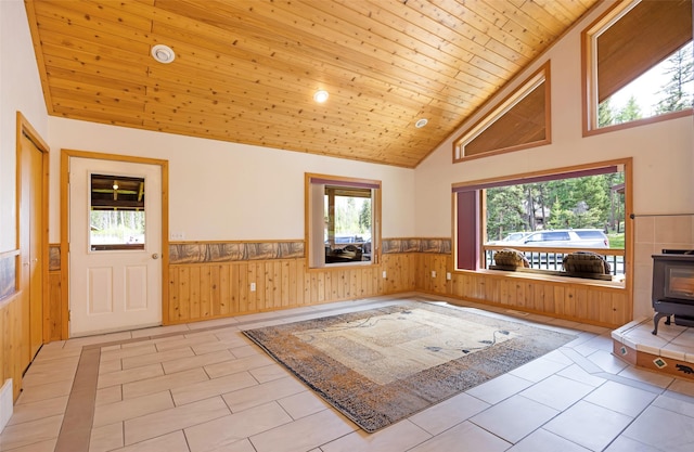 1065 Evergreen Dr, Seeley Lake, MT 59868 - entrance foyer featuring wainscoting, a wood stove, wood walls, high vaulted ceiling, and wooden ceiling