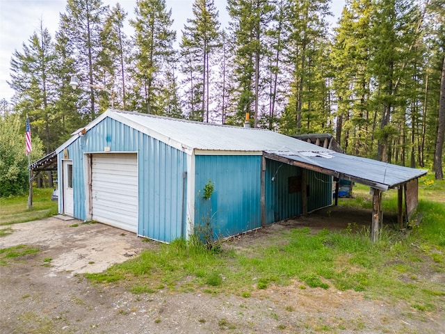 137 Amber Rd, Troy, MT 59935 - garage featuring a garage, dirt driveway, and view of scattered trees