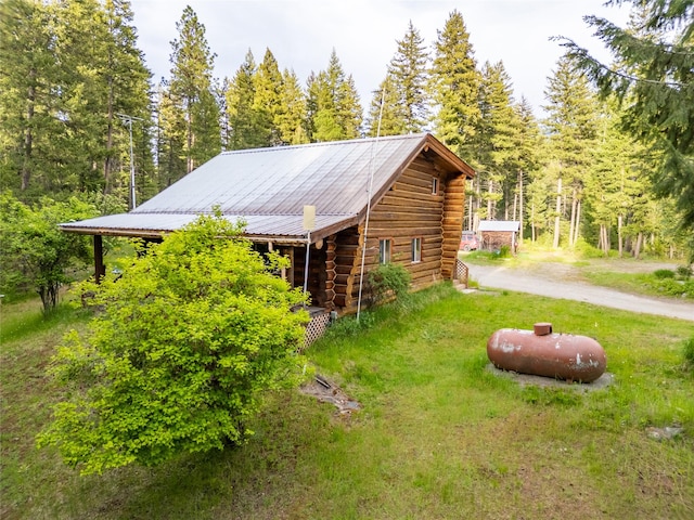 137 Amber Rd, Troy, MT 59935 - view of side of property with log exterior, metal roof, a wooded view, and driveway