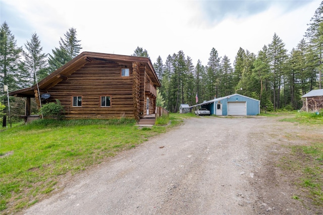 137 Amber Rd, Troy, MT 59935 - view of property exterior featuring a garage, driveway, an outdoor structure, and log siding