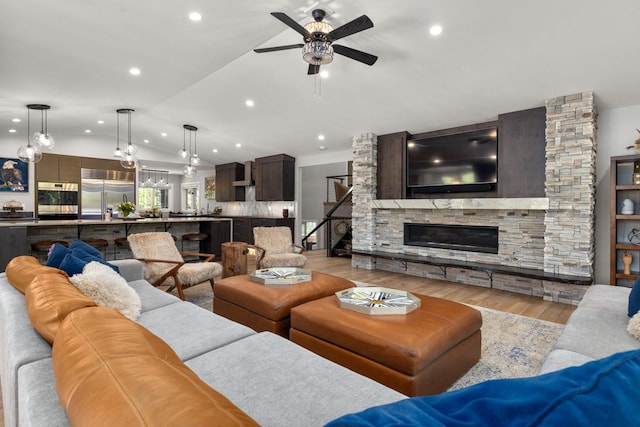 309 Fairway Dr, Whitefish, MT 59937 - living room featuring lofted ceiling, light wood finished floors, ceiling fan, recessed lighting, and a stone fireplace