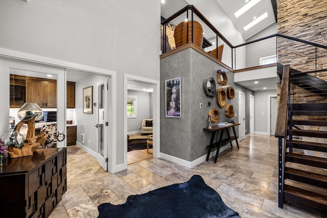 309 Fairway Dr, Whitefish, MT 59937 - foyer featuring stone tile floors, high vaulted ceiling, and stairway