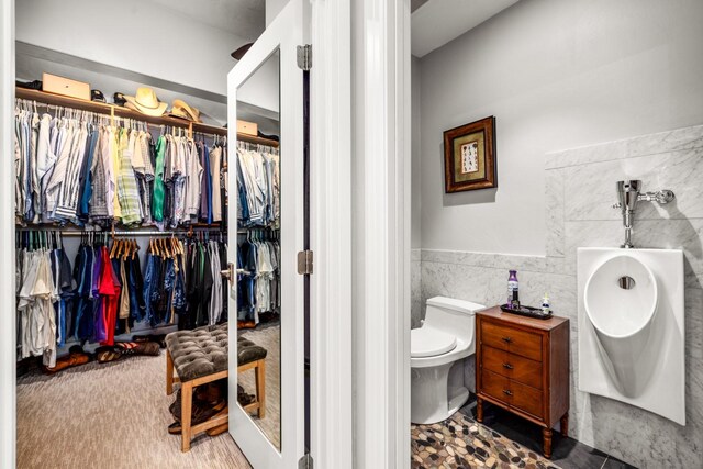 309 Fairway Dr, Whitefish, MT 59937 - bathroom with tile walls, a spacious closet, and a tub to relax in
