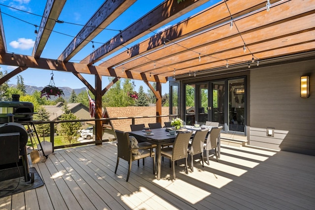 309 Fairway Dr, Whitefish, MT 59937 - wooden terrace featuring a mountain view, outdoor dining area, and a pergola