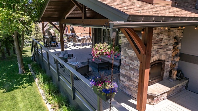 309 Fairway Dr, Whitefish, MT 59937 - deck featuring an outdoor stone fireplace, outdoor dining space, and a yard