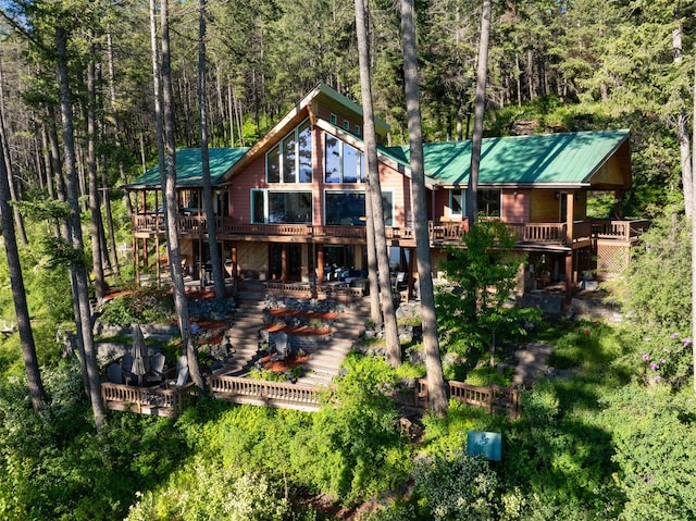 14690 Shore Acres Dr, Bigfork, MT 59911 - rear view of property with a wooden deck, a forest view, stairway, and metal roof