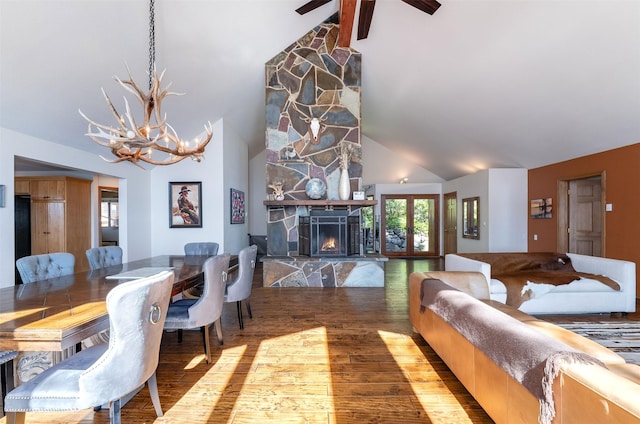14690 Shore Acres Dr, Bigfork, MT 59911 - dining room featuring high vaulted ceiling, wood finished floors, a chandelier, a stone fireplace, and beamed ceiling
