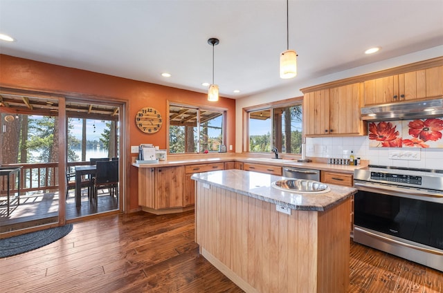 14690 Shore Acres Dr, Bigfork, MT 59911 - kitchen featuring appliances with stainless steel finishes, under cabinet range hood, recessed lighting, decorative backsplash, and a center island
