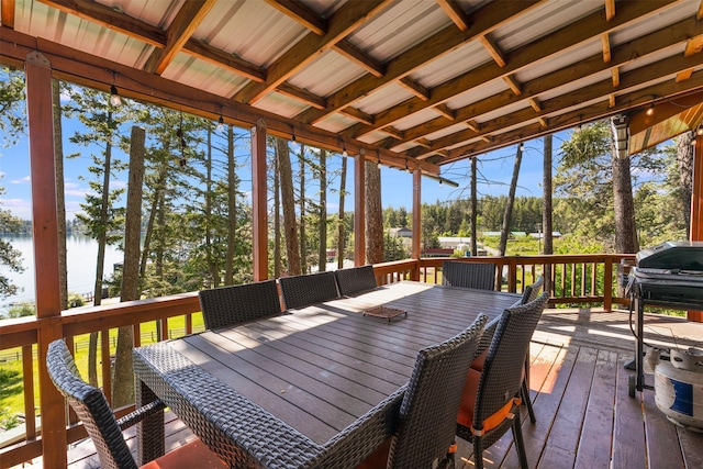 14690 Shore Acres Dr, Bigfork, MT 59911 - wooden deck with outdoor dining space, a water view, a grill, and view of scattered trees