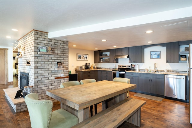 14690 Shore Acres Dr, Bigfork, MT 59911 - dining space featuring dark wood-style floors, a fireplace, and recessed lighting