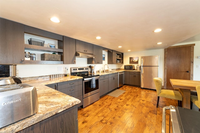 14690 Shore Acres Dr, Bigfork, MT 59911 - kitchen with stainless steel appliances, under cabinet range hood, a sink, open shelves, and gray cabinetry
