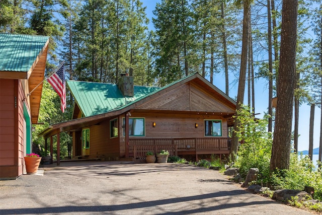 14690 Shore Acres Dr, Bigfork, MT 59911 - view of front of property featuring asphalt driveway, metal roof, a chimney, and a deck