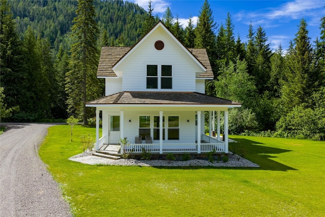 189 Blue Creek Rd, Heron, MT 59844 - view of front facade with a forest view, a porch, and a front lawn