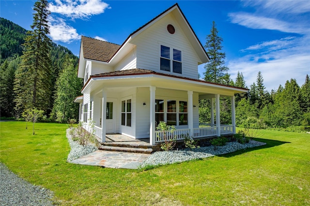 189 Blue Creek Rd, Heron, MT 59844 - country-style home featuring covered porch, a view of trees, and a front lawn