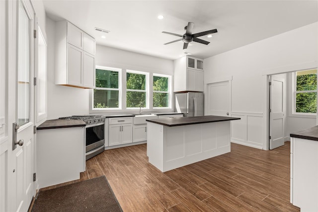 189 Blue Creek Rd, Heron, MT 59844 - kitchen featuring stainless steel appliances, dark countertops, a sink, white cabinets, and ceiling fan