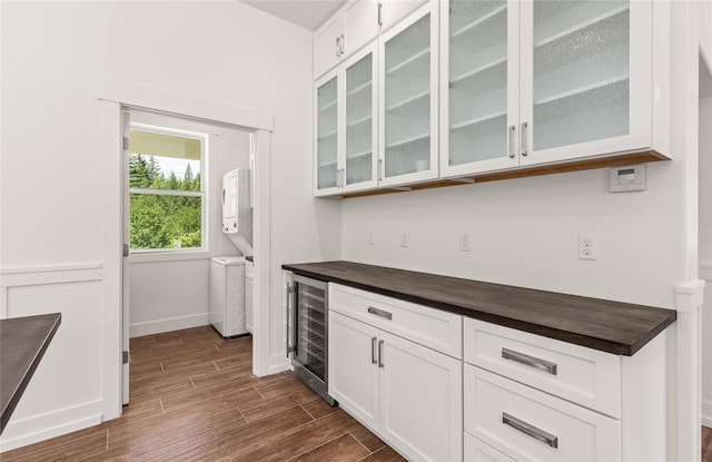 189 Blue Creek Rd, Heron, MT 59844 - bar area featuring beverage cooler, stacked washer / dryer, dark wood-type flooring, and baseboards