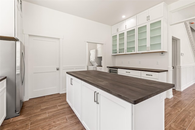 189 Blue Creek Rd, Heron, MT 59844 - kitchen featuring freestanding refrigerator, butcher block counters, wood finished floors, white cabinetry, and a wainscoted wall