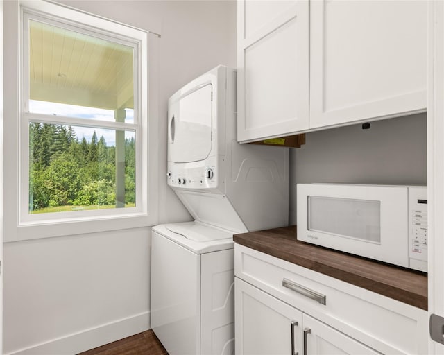 189 Blue Creek Rd, Heron, MT 59844 - laundry room with stacked washing machine and dryer, cabinet space, and baseboards