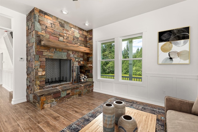 189 Blue Creek Rd, Heron, MT 59844 - living area with a decorative wall, wood finished floors, wainscoting, and a stone fireplace