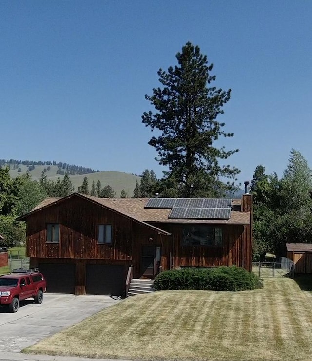 1114 Creek Crossing Rd, Missoula, MT 59802 - view of front facade featuring roof mounted solar panels, concrete driveway, and a shingled roof
