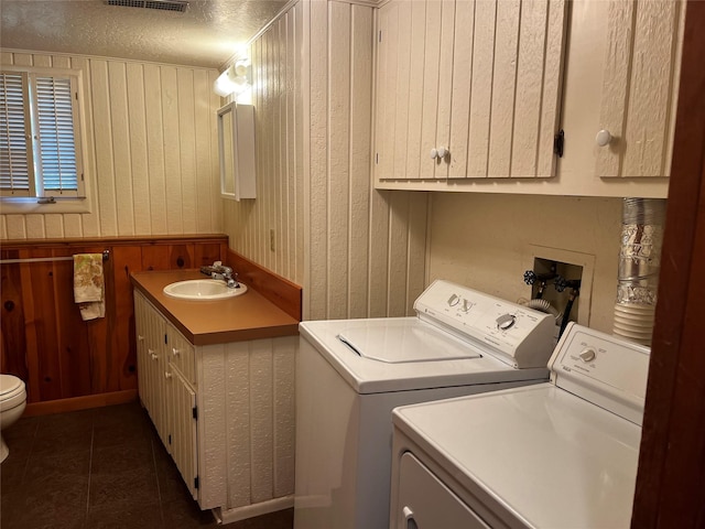 1114 Creek Crossing Rd, Missoula, MT 59802 - laundry room featuring washer and dryer, wooden walls, dark tile patterned floors, and a textured ceiling