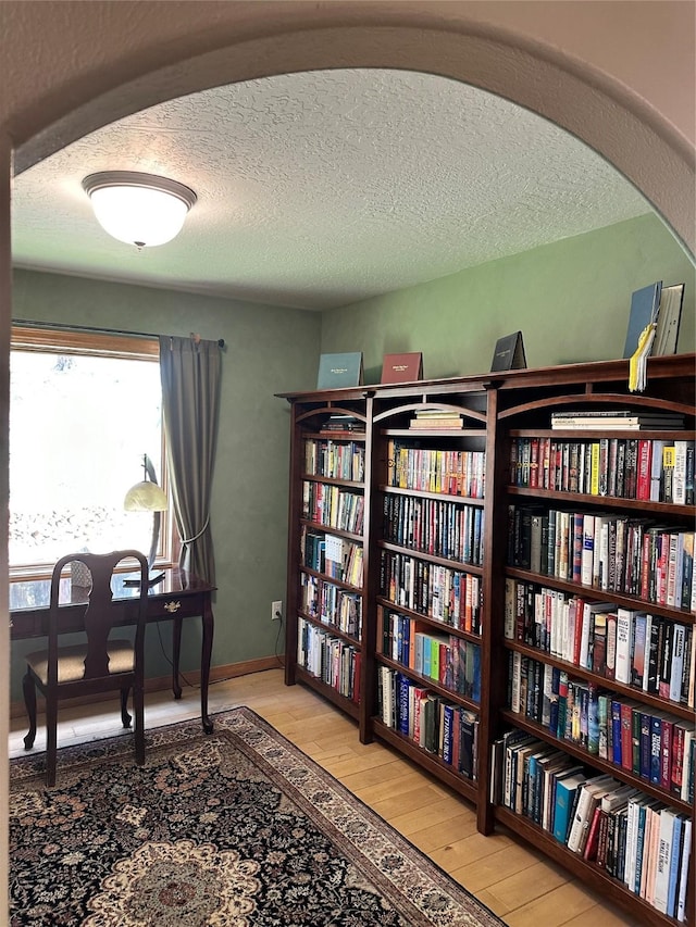 340 Elkhorn Rd, Seeley Lake, MT 59868 - living area featuring hardwood / wood-style floors, bookshelves, and a textured ceiling