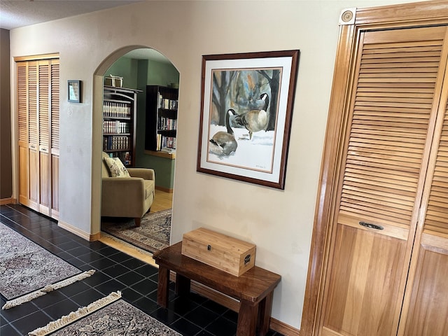 340 Elkhorn Rd, Seeley Lake, MT 59868 - hallway featuring arched walkways, dark tile patterned floors, and baseboards