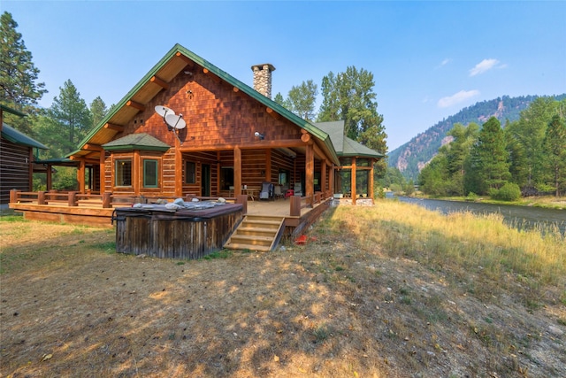 6900 Nez Perce Rd, Darby, MT 59829 - back of house with a hot tub, a chimney, and a deck with mountain view