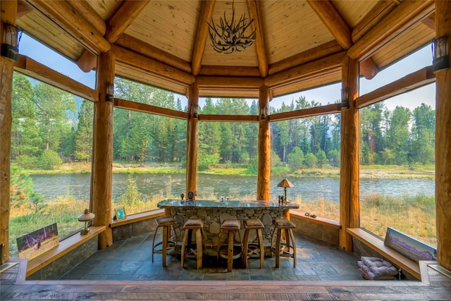 6900 Nez Perce Rd, Darby, MT 59829 - sunroom / solarium with wooden ceiling, stone tile flooring, a water view, and view of scattered trees