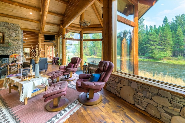 6900 Nez Perce Rd, Darby, MT 59829 - living area with wooden ceiling with exposed beams, wood-type flooring, high vaulted ceiling, and a stone fireplace