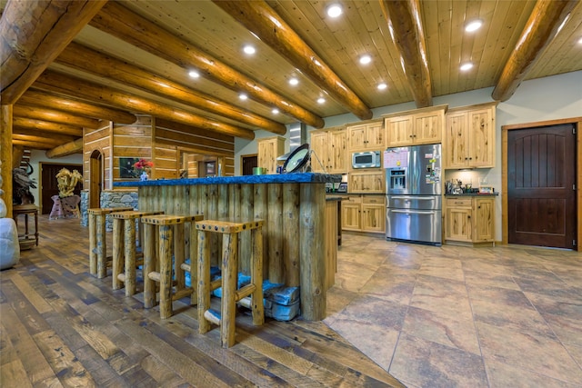 6900 Nez Perce Rd, Darby, MT 59829 - kitchen with appliances with stainless steel finishes, dark countertops, recessed lighting, a kitchen breakfast bar, and beamed ceiling