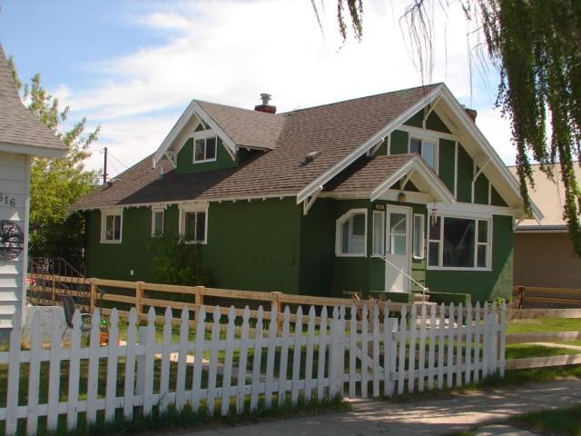 808 W 4th St, Anaconda, MT 59711 - view of front facade with a fenced front yard, roof with shingles, a chimney, and stucco siding